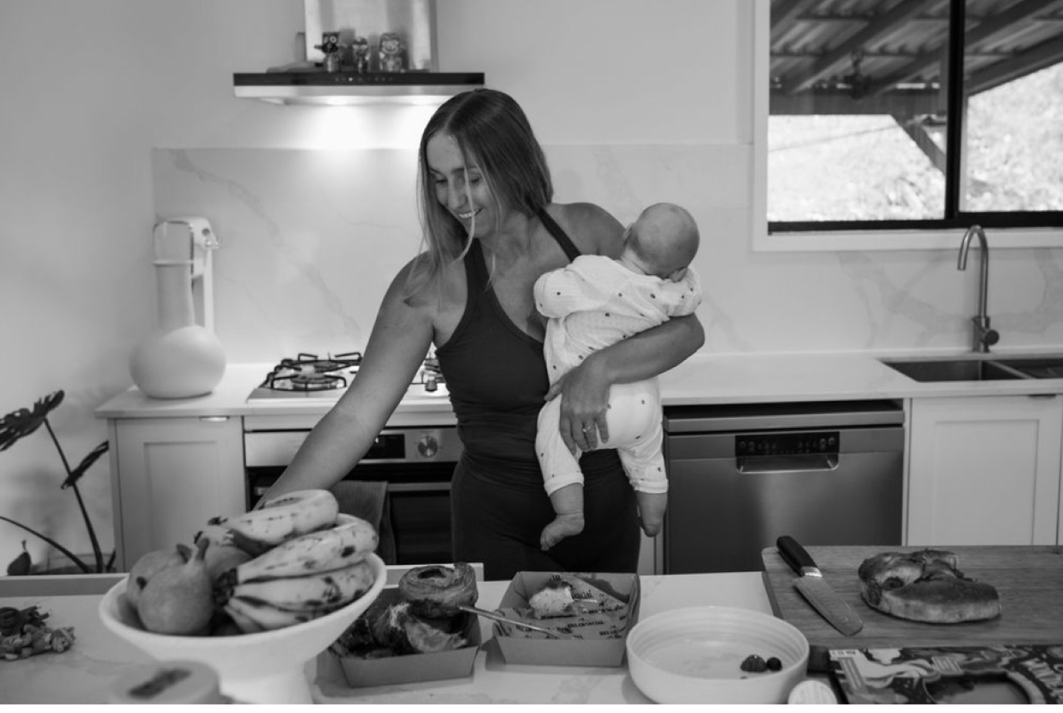 Mother holding her baby in the kitchen